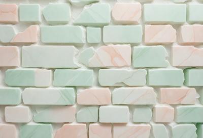The primary subject of the image is a wall made of marble tiles. The setting is a room with a white wall, and the visual style is a photo. The colors and mood of the image are predominantly pink and white, creating a warm and inviting atmosphere.
