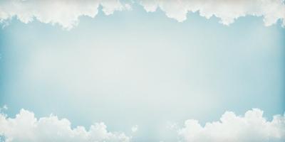The primary subject of the image is a large, blue, cloudy sky. The setting is a vast, open space with no visible landmarks or objects. The visual style is a photo, capturing the beauty of the cloudy sky. The colors and mood of the image are predominantly blue and serene, creating a sense of tranquility and vastness.