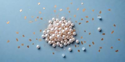 The primary subject of the image is a pile of white pearls. The pearls are scattered on a blue surface, which could be a table or a wall. The visual style of the image is a close-up of the pearls, showcasing their beauty and texture. The colors and mood of the image are predominantly blue and white, creating a calm and elegant atmosphere.
