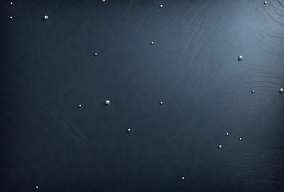 The primary subject of the image is a blue surface with a pattern of white dots. The setting appears to be a dark room, and the visual style is a close-up of the blue surface with the white dots. The colors and mood of the image are predominantly dark and moody, with the white dots providing a contrasting element.