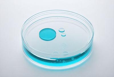 The primary subject of the image is a clear plastic cup filled with blue liquid. The cup is placed on a white surface, which serves as the background. The visual style of the image is a close-up of the cup, showcasing its contents. The dominant colors in the image are blue and white, creating a calm and soothing atmosphere.