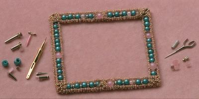The primary subject of the image is a beaded frame with a pink background. The frame is adorned with various beads, including green and pink ones. The setting is a pink surface, and the visual style appears to be a combination of a photo and a digital artwork. The colors and mood of the image are predominantly pink and warm, creating a sense of elegance and charm.