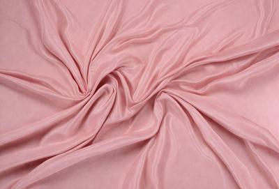 The primary subject of the image is a pink fabric, which is the main object, scene, or focus of the image. The setting or background is a pink sheet, and the visual style is a close-up of the fabric. The colors and mood of the image are predominantly pink, creating a warm and inviting atmosphere.