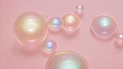 The primary subject of the image is a group of three large, round, and clear bubbles floating on a pink surface. The setting is a pink background, which adds a warm and inviting atmosphere to the scene. The visual style is a close-up of the bubbles, showcasing their unique and captivating appearance. The colors and mood of the image are predominantly pink, creating a sense of warmth and softness.