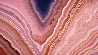 The primary subject of the image is a close-up of a rock formation, showcasing its unique and intricate patterns. The setting is a natural environment, with the rock formation being the main focus of the scene. The visual style of the image is a close-up, which emphasizes the details of the rock formation. The colors and mood of the image are predominantly earthy tones, giving it a natural and serene atmosphere.