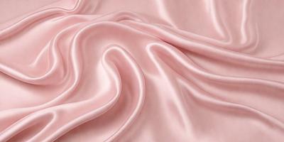 The primary subject of the image is a close-up of a pink fabric, possibly silk, with a smooth and shiny texture. The setting is a pink background, which complements the fabric's color. The visual style appears to be a photo, showcasing the fabric's details and texture. The colors and mood of the image are predominantly pink, creating a warm and inviting atmosphere.