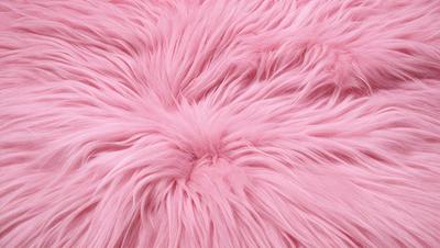 The primary subject of the image is a large, pink, fuzzy, and fluffy surface, which appears to be a piece of pink fur or a pink fabric. The setting is a close-up of the pink surface, showcasing its texture and color. The visual style is a realistic representation of the pink fur or fabric, with no indication of digital art, illustration, drawing, pattern, texture, or clipart. The colors and mood of the image are predominantly p