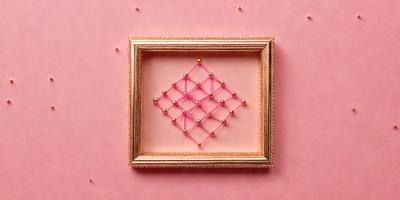 The primary subject of the image is a pink frame with a pink background. The setting is a pink surface, which creates a warm and inviting atmosphere. The visual style is a combination of a photo and a drawing, giving the image a unique and artistic appearance. The colors and mood are predominantly pink, creating a sense of femininity and warmth.