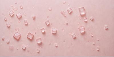 The primary subject of the image is a close-up of a pink surface with water droplets on it. The setting is a pink background, and the visual style is a photo. The colors and mood of the image are predominantly pink, creating a warm and inviting atmosphere.