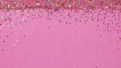 The primary subject of the image is a pink background with a pattern of glittery gold confetti. The setting is a pink surface, and the visual style appears to be a combination of a photo and digital art. The colors and mood of the image are predominantly pink and gold, creating a warm and festive atmosphere.
