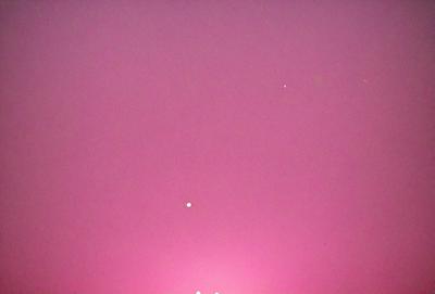 The primary subject of the image is a pink sky, which appears to be a sunset. The setting is a vast, open space with no visible landmarks or objects. The visual style is a natural, outdoor scene with a warm, colorful atmosphere.