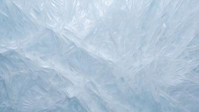 The primary subject of the image is a large, blue, frosty-looking surface, possibly a wall or a piece of art. The setting appears to be a cold, icy environment. The visual style of the image is a combination of a photo and digital art, creating a unique and intriguing appearance. The dominant colors in the image are blue and white, giving it a chilly and frosty atmosphere.