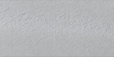The primary subject of the image is a white wall with a textured surface. The setting is a room with a white background. The visual style is a close-up of the wall, showcasing its texture. The colors and mood of the image are predominantly white, giving it a clean and minimalist appearance.