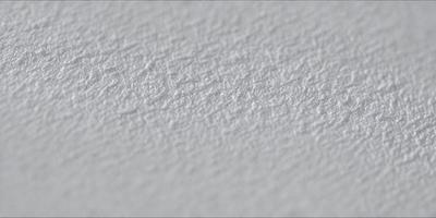The primary subject of the image is a white wall with a textured surface. The setting is a room with a white background. The visual style is a close-up of the wall, showcasing its texture. The colors and mood of the image are predominantly white, giving it a clean and minimalist appearance.