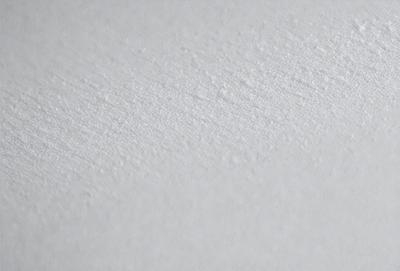 The primary subject of the image is a white wall with a smooth, textured surface. The setting is a room with a white background, which creates a clean and minimalistic atmosphere. The visual style is a close-up of the wall, showcasing its texture and appearance. The colors and mood of the image are predominantly white, giving it a calm and serene feel.