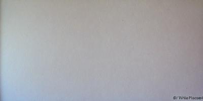The image is a white background with a single black dot in the center. The black dot is the primary subject, and the white background provides a clean and minimalistic setting. The visual style is simple and straightforward, with no additional elements or colors. The mood of the image is calm and uncluttered, as it focuses solely on the black dot in the center of the white background.