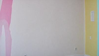 The image features a white wall with a single electrical outlet on the right side. The wall is clean and uncluttered, giving it a minimalist appearance. The primary subject of the image is the electrical outlet, which stands out against the white wall.
