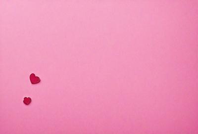 The primary subject of the image is a heart-shaped object, which is placed on a pink background. The heart is the main focus of the image, and it appears to be a digital art or illustration. The setting is a pink wall, and the visual style is a combination of digital art and illustration. The colors and mood of the image are predominantly pink, creating a warm and inviting atmosphere.
