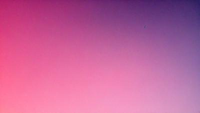 The primary subject of the image is a pink sky, which creates a warm and inviting atmosphere. The setting is a cloudy sky, with a few clouds visible in the background. The visual style of the image is a photo, capturing the beauty of the pink sky. The colors and mood of the image are predominantly pink, giving it a serene and calming feel.