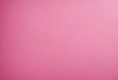 The primary subject of the image is a pink background. The setting is a blank, pink wall, which serves as the backdrop for the image. The visual style is a close-up of the pink wall, showcasing its texture and color. The colors and mood of the image are predominantly pink, creating a warm and inviting atmosphere.