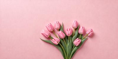 The primary subject of the image is a bouquet of pink tulips. The setting is a pink background, which creates a visually appealing contrast with the flowers. The visual style is a close-up of the flowers, showcasing their details and beauty. The colors and mood of the image are predominantly pink, which gives it a warm and inviting atmosphere.