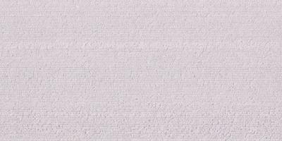 The primary subject of the image is a white wall with a patterned texture. The setting is a room with a white surface, and the visual style appears to be a photo. The dominant colors are white and gray, creating a clean and minimalist atmosphere.