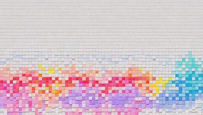 The primary subject of the image is a large brick wall with a colorful pattern. The setting is a brick wall, and the visual style is a combination of photo and digital art. The colors and mood of the image are vibrant and lively, with a mix of pink, purple, and yellow colors.