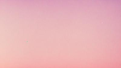 The primary subject of the image is a pink sky. The setting is a vast, open space with no visible landmarks or objects. The visual style is a natural, outdoor scene. The colors and mood are predominantly pink, creating a serene and calming atmosphere.