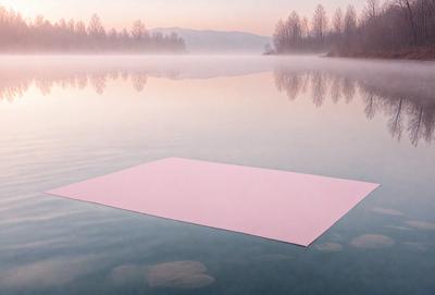 The primary subject of the image is a pink square floating on a body of water. The setting is a lake, and the visual style appears to be a photo. The colors in the image are predominantly pink, creating a warm and inviting atmosphere.