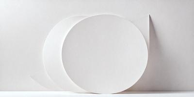 The primary subject of the image is a white circle, which is the main object, scene, or focus of the image. The circle is placed on a white surface, which serves as the setting or background. The visual style of the image is a photo, as it captures a real-life scene. The colors and mood of the image are predominantly white, giving it a clean and minimalist appearance.