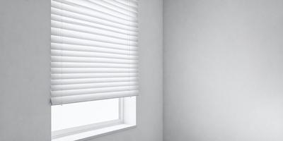 The primary subject of the image is a white shade on a window. The setting is a white wall, and the visual style is a photo. The colors and mood of the image are predominantly white, creating a clean and minimalist atmosphere.