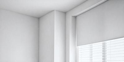 The primary subject of the image is a white wall with a window. The setting is a room with a window, and the visual style is a photo. The colors and mood of the image are predominantly white, creating a clean and minimalist atmosphere.
