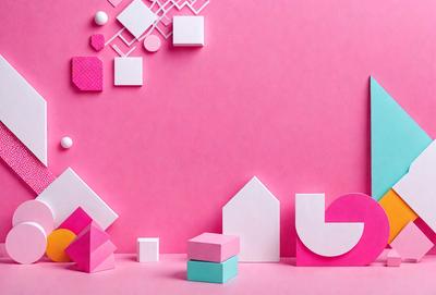 The primary subject of the image is a collection of geometric shapes, including squares, triangles, and circles, arranged on a pink background. The shapes are made of paper and are placed in various positions, creating a visually appealing and creative display. The setting is a pink wall, which serves as the backdrop for the shapes. The visual style of the image is a combination of digital art and illustration, with the shapes appearing to be cut out from a larger surface. The colors and mood of the image are pre