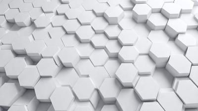 The primary subject of the image is a white wall with a pattern of white hexagons. The setting is a white room, and the visual style is a close-up of the wall. The dominant colors are white, and the overall atmosphere is clean and minimalistic.