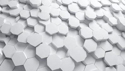 The primary subject of the image is a white wall with a pattern of white hexagons. The setting is a white wall, and the visual style is a close-up of the hexagonal pattern. The colors and mood of the image are predominantly white, giving it a clean and minimalist appearance.