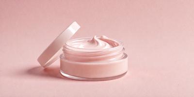 The primary subject of the image is a jar of pink cream, which is placed on a pink surface. The jar is filled with a pink substance, which appears to be a cream or a similar product. The setting is a pink background, which complements the color of the jar and the cream. The visual style of the image is a close-up of the jar, showcasing the pink substance inside. The colors and mood of the image are predominantly pink, creating a