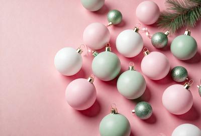 The primary subject of the image is a group of Christmas ornaments. The ornaments are predominantly pink and green, and they are arranged on a pink surface. The setting appears to be a festive and holiday-themed environment. The visual style of the image is a close-up of the ornaments, showcasing their colors and details. The overall atmosphere of the image is cheerful and celebratory, as it captures the essence of the holiday season.