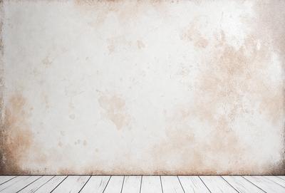 The primary subject of the image is a white wall with brown stains on it. The setting is a room with a wooden floor. The visual style is a photo, and the colors and mood are predominantly white and brown, giving the wall a worn and aged appearance.