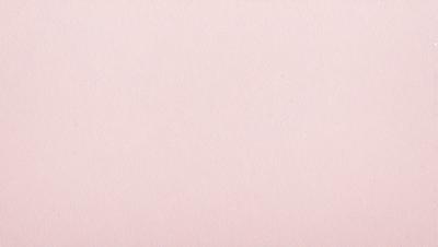 The primary subject of the image is a large sheet of pink paper. The setting is a blank, white wall, which serves as the background. The visual style is a close-up of the pink paper, showcasing its texture and color. The colors and mood of the image are predominantly pink, creating a warm and inviting atmosphere.