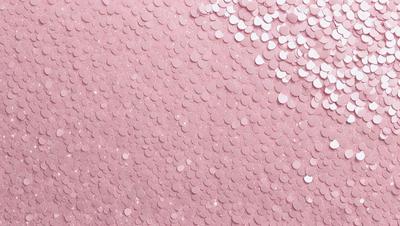 The primary subject of the image is a pink background with a pattern of white circles. The setting is a pink wall, and the visual style is a close-up of the wall. The dominant colors are pink and white, creating a warm and inviting atmosphere.