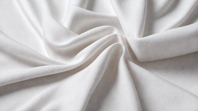 The primary subject of the image is a white sheet of fabric, which is the main object, scene, or focus of the image. The setting is a white background, which provides a clean and minimalistic environment. The visual style is a close-up of the fabric, showcasing its texture and details. The colors and mood of the image are predominantly white, giving it a clean and serene atmosphere.