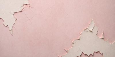 The primary subject of the image is a pink wall with peeling paint. The setting is a room with a pink wall, and the visual style is a close-up of the wall. The colors and mood of the image are predominantly pink, giving it a warm and inviting atmosphere.