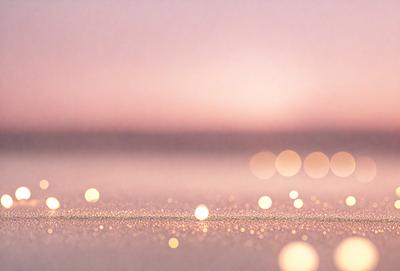 The primary subject of the image is a beach scene with a pink sky. The setting is a sandy beach, and the visual style is a photo. The colors and mood of the image are predominantly pink, creating a warm and serene atmosphere.