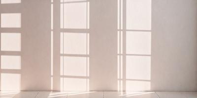 The primary subject of the image is a white wall with a window. The setting is a room with a window, and the visual style is a photo. The colors and mood of the image are predominantly white, creating a clean and minimalist atmosphere.