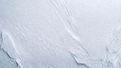 The image features a large, white, and textured surface, possibly a wall or a piece of art. The primary subject is a close-up of the surface, showcasing its intricate texture and design. The setting or background is a white, snowy environment, which adds to the overall mood and atmosphere of the image. The visual style is a combination of photo and digital art, creating a unique and captivating piece.