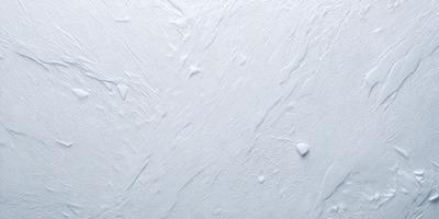 The primary subject of the image is a white, textured surface. The setting is a white wall, and the visual style is a close-up of the wall. The colors and mood of the image are predominantly white, giving it a clean and minimalist appearance.