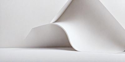 The primary subject of the image is a white sheet of paper. The setting is a white background, which creates a clean and minimalist appearance. The visual style is a close-up of the paper, emphasizing its texture and details. The colors and mood of the image are predominantly white, giving it a calm and serene atmosphere.