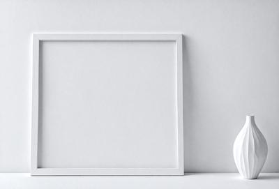The primary subject of the image is a white frame, which is placed on a white background. The visual style of the image is a photo, and the colors and mood are predominantly white, giving the scene a clean and minimalist appearance.