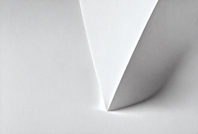 The primary subject of the image is a white paper, which is the main object, scene, or focus of the image. The setting is a white background, and the visual style is a photo. The colors and mood of the image are predominantly white, giving it a clean and minimalist appearance.