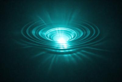 The primary subject of the image is a blue, glowing, circular wave in the ocean. The wave appears to be a vortex, with a bright light shining through it. The setting is the ocean, with the wave being the main focus of the image. The visual style is a photo, capturing the vibrant colors and unique formation of the wave. The colors and mood of the image are predominantly blue and serene, creating a sense of calmness and beauty.